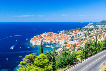 Wall Mural - Panoramic view of Old Town medieval Ragusa and Dalmatian Coast of Adriatic Sea in Dubrovnik. Blue sea with white yachts, beautiful landscape, aerial view, Dubrovnik, Croatia