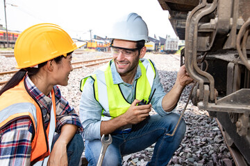 Asian and assistant industrial workers are plan and discussing engines at train station garage plants with and walkie takie. Engineer and repair man concept. Safty first