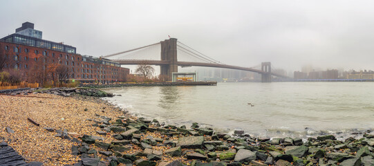 Fototapete - Brooklyn bridge and east river at foggy rainy day, New York City