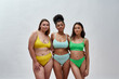 Studio shot of lovely young women with different body shapes wearing colorful underwear posing together over light background