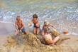© Nataliia Makarovska - happy children are building a castle from the sand by the sea on the beach on a summer day, horizontal format