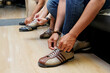 © DragonImages - Close-up of people wearing shoes before playing bowling in entertainment center