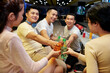 © DragonImages - Group of friends toasting with drinks and having fun together during bowling game