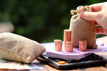 Wall Mural - stack of coin with calculator on table background and saving money and business growth concept,finance and investment concept