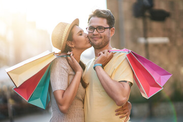 Wall Mural - Happy couple with shopping bags in the city