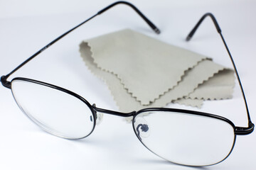 Wall Mural - Black frame glasses with glasses cleaning cloth on a white background. Close up photo.