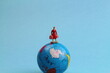 kleine Figur auf einem Globus 