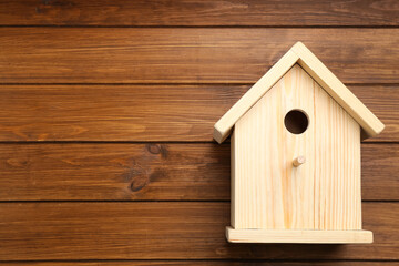 Beautiful bird house on wooden background, space for text