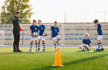 Wall Mural - School Boys on Soccer Pitch. Young Coach Talking to Football Players During Training Session. Practice Unit for Youth Sports Team