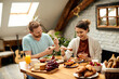 © Drazen - Young happy couple enjoying in breakfast at dining table at home.