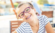 Leinwandbild Motiv Young preteen girl in glasses wearing braces smiles at the camera on a summer day