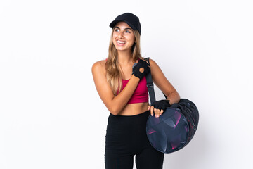 Wall Mural - Young sport woman with sport bag over isolated white background looking up while smiling