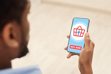 African american man using shopping application on mobile phone