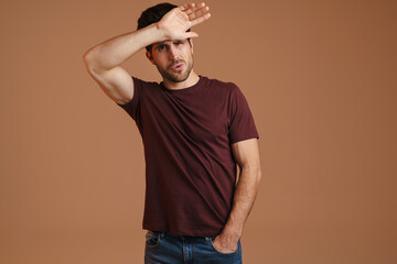 Canvas Print - Displeased young man with headache touching his forehead