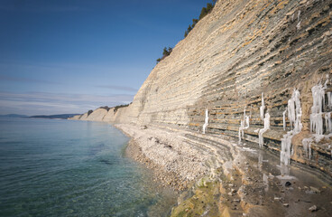 Wall Mural - Beautiful landscape sea view. Shore with white pebbles and rocks on a spring day