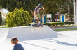 © Jose Prieto - Teenage boy in skateboard park against blue sky