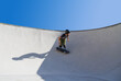 © Jose Prieto - Teenage boy in skateboard park against blue sky