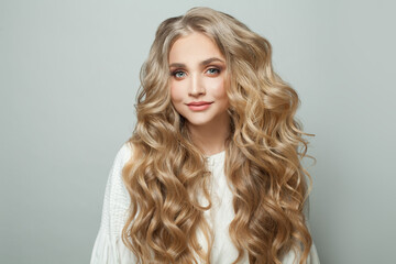 Wall Mural - attractive blonde woman with long perfect hair looking at camera and smiling on white background