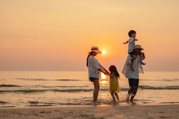 Wall Mural - Happy asian family that enjoys beach activities during the summer holidays. parent and children enjoy the sunset sea on beach.Holiday travel concept, Summer vacations.