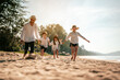 © Garun Studios - Happy family, Parents are holding hands their children and walking on the beach in holiday.Family, travel, beach, relax, lifestyle, holiday concept.
