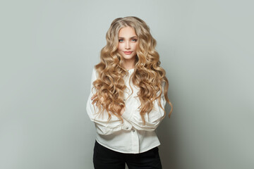 Wall Mural - blonde woman student smiling and standing on white background