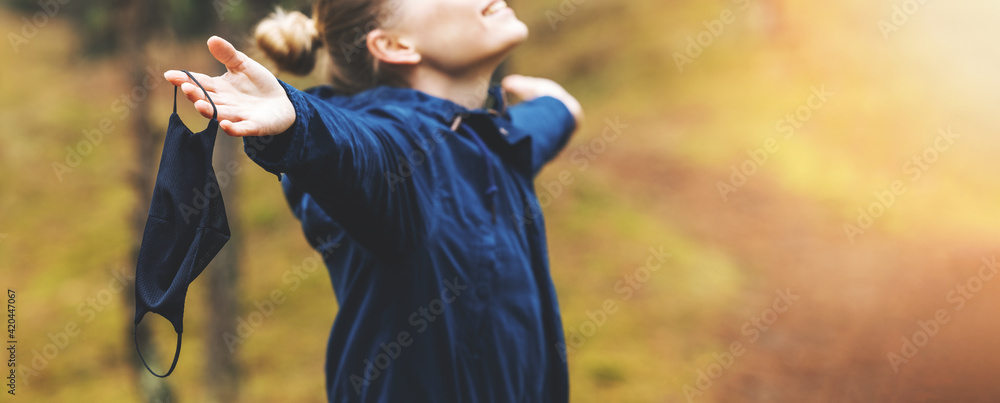 woman enjoying nature and fresh air with removed face mask. mental health and relief during pandemic. banner copy space - obrazy, fototapety, plakaty 