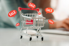 Online Shopping Concept During The Sale Period, Bright Orange Price Tag Icon With A Shopping Cart As A Background.