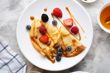 Wall Mural - Overhead view of  plate with breakfast crepe and berries, blini