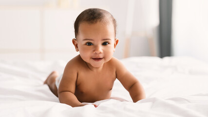 Wall Mural - Cute little African American infant lying on bed