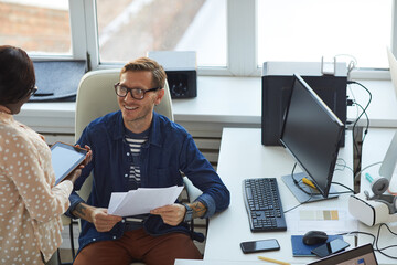 Smiling Businessman Talking to Assistant in Office