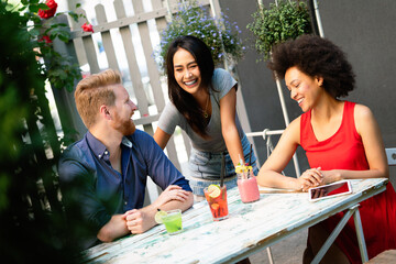 Multiracial group of friends having fun and talking in restaurant