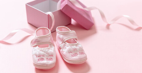 Wall Mural - It’s a girl announcement. Baby girl pink shoes on pink color background. Baby shower, christening concept.