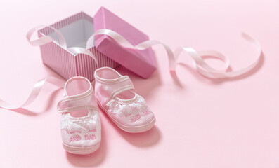 Wall Mural - It’s a girl announcement. Baby girl pink shoes on pink color background. Baby shower, christening concept.