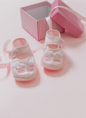 Wall Mural - It’s a girl announcement. Baby girl pink shoes on pink color background. Baby shower, christening concept.