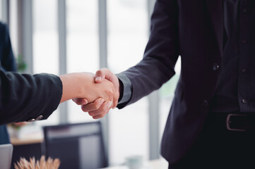 Wall Mural - Business man in a suit shakes hands to agree a business partnership agreement. Business etiquette concept of congratulation, concept of handshake during office meeting.