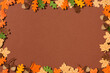 © Maki Company Limited/Stocksy - Frame of yellow maple leaves, red oak leaves, pear and acorns