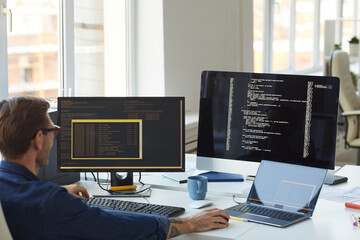 Male IT Programmer Using Computers with Code on Screen