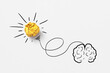 © Yaroslav Danylchenko/Stocksy - Sketch of human brain with lighting paper bulb.