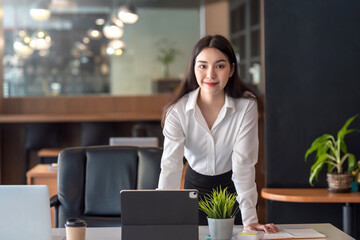 Beautiful businesswoman stand and look at the camera at the office