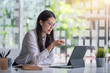 © amnaj - Asian businesswoman working in the office point to tablet.