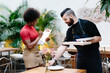 © Jimena Roquero/Stocksy - Restaurant manager supervising table setting