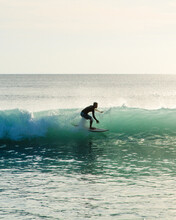 Silhouette Of A Surfer On A Blue Wave