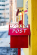 © Lawren Lu/Stocksy - Red metal mailbox on house wall with post word on it