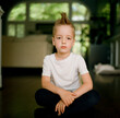 © Jakob Lagerstedt/Stocksy - Handsome young boy with a mohawk haircut sitting on the floor