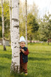 © Alina Hvostikova/Stocksy - Boy hiding behind birch tree