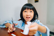 © Pansfun Images/Stocksy - Little girl cutting paper with scissors