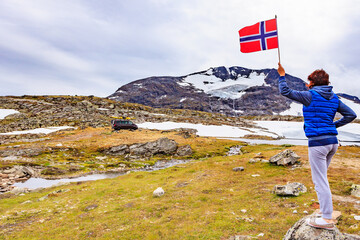 Sticker - Woman holds norwegian flag in mountains Norway