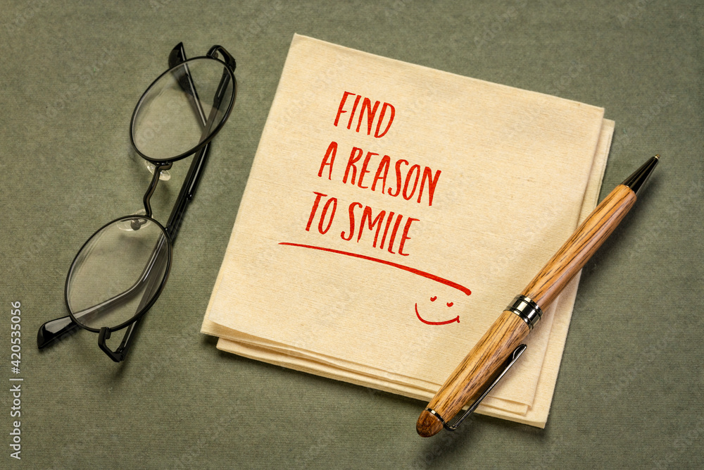 Find a reason to smile - inspirational handwriting on a napkin with a cup of coffee, positive attitude and mindset concept - obrazy, fototapety, plakaty 