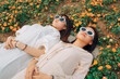 © Pansfun Images/Stocksy - Two young women lying in flowers enjoying the sun