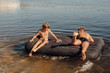 © Julie Meme/Stocksy - Two boys swim on an inflatable mattress